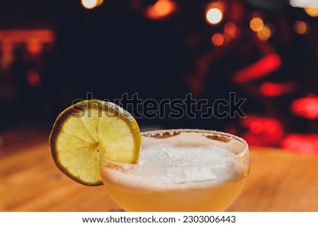 Glass of iced tea with lemon slices and mint on white wooden table