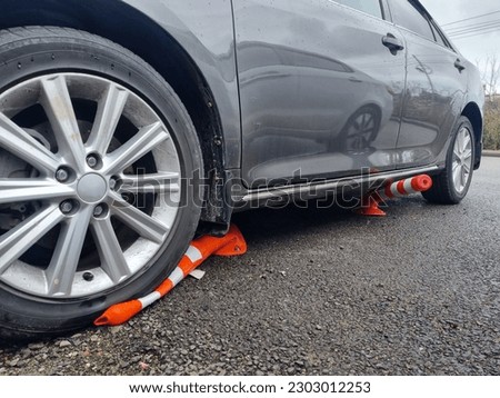 violation of markings in the parking lot. the car is parked with wheels on the barrier cones. violation of traffic rules.