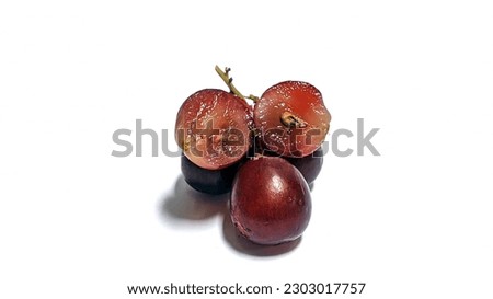Red grapes with green leaves and half sliced isolated on white background
