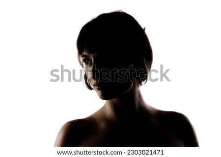 silhouette studio portrait of a beautiful brunette girl with short hair against white background. Royalty-Free Stock Photo #2303021471