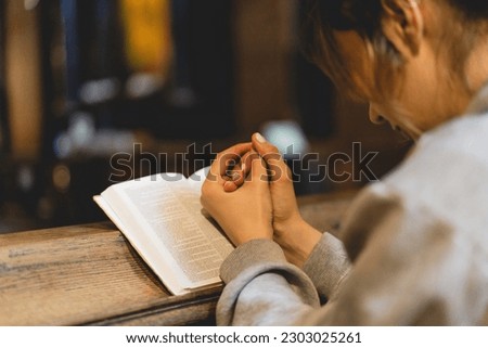 Christian woman reading bible in an ancient Catholic temple. Reading the Holy Bible in temple. Concept for faith, spirituality and religion. Peace, hope, dreams concept Royalty-Free Stock Photo #2303025261