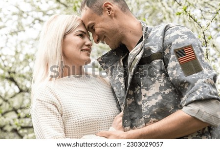 Happy young soldier smiling cheerfully while standing outside his home. Patriotic American serviceman coming back home after serving his country in the military