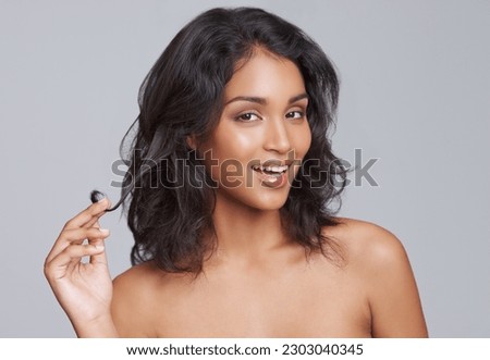 Portrait, skincare and hair with a woman in studio on a gray background for natural haircare treatment. Face, beauty and shampoo with a young female model from India at the salon for a haircut