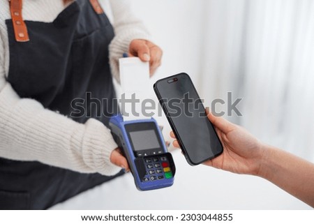 Photo of asian small business owner and contactless or wireless payment concept