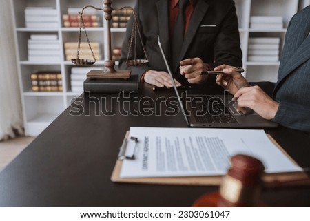 Businessmen and lawyers discuss treaty documents And the information on the laptop to clarify the legal information before signing the contract to invest in the business.