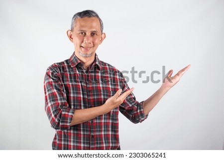 Portrait of Adult Asian Man pointing hands and finger to the side. (explain something)
