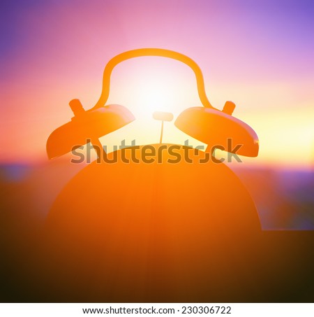 alarmclock silhouette at sunrise cityscape Royalty-Free Stock Photo #230306722