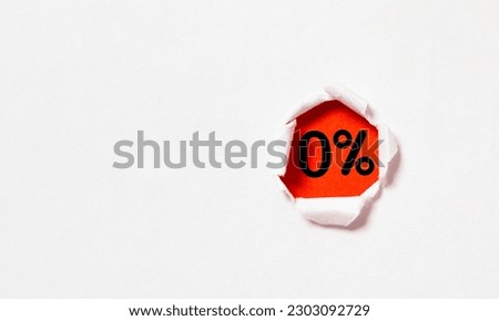 Zero percentage or 0% inside red punch paper for special offer of shopping department store discount and banking interest rate concept.