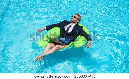 man trader work and relax in swimming pool on ring. man trader work and relax with laptop.