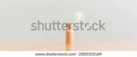 Wooden figurine as person who have questions and need help solving the problems. Man has no idea on wood table. Business marketing and Creative solution concept.