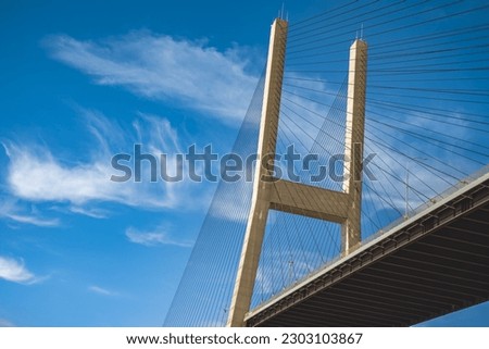 Modern bridge pylon against a blue sky. Detail of the multi-span cable-stayed bridge. Linear perspective view of a cable-stayed suspension Alex Fraser Bridge in BC. Nobody, selective focus Royalty-Free Stock Photo #2303103867