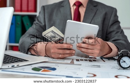 Close up of hands of business man working on paper with many documents charts and laptop and dollars. concept of office work