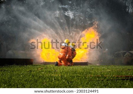 Firefighter Concept. Fireman using water and extinguisher to fighting with fire flame. firefighters fighting a fire with a hose and water during a firefighting training exercise