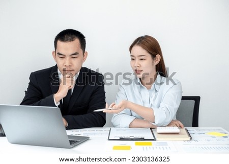 Two business people sitting at workplace and discussing about earnings on a graph to plan investments in the office room. business discussing and planning strategy concept.