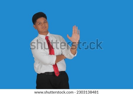 Asian male party cadre in tie pointing up with number five finger smiling confident and happy for election campaign isolated on blue background.