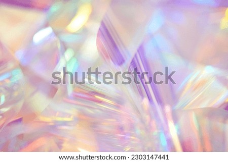 Blurred closeup of ethereal pastel neon pink, purple, lavender, orange, yellow holographic metallic foil background. Abstract modern surreal futuristic disco, rave, techno, festive dreamlike backdrop