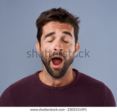 Tired, yawn and man in studio for fatigue or low energy against a grey background. Exhausted, yawning and face of bored male sleepy, lazy or suffering from insomnia, problem or burnout with emoji Royalty-Free Stock Photo #2303151491