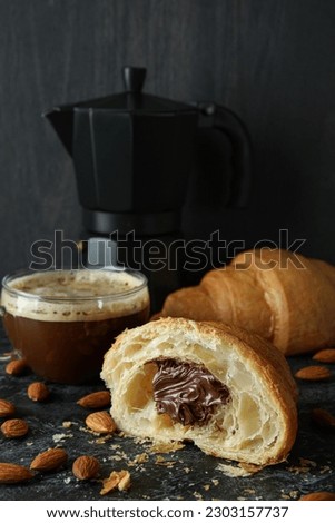 Concept of tasty breakfast with croissant with chocolate on dark background