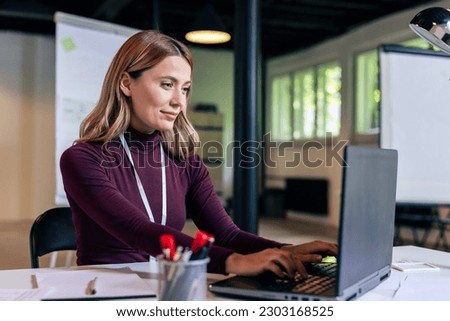 Young businesswoman working on her laptop in the modern office.
