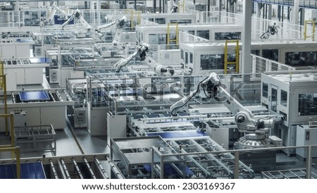 Solar Panels are being Assembled on Conveyor. Large Production Line with White Industrial Robot Arms at Modern Bright Factory. Automated Manufacturing Facility.