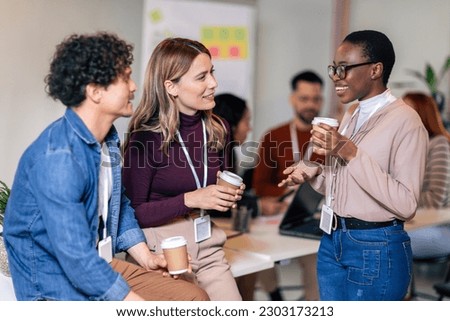 Happy diverse colleagues have fun at lunch break in office, smiling multiracial employees laugh and talk  drinking coffee Royalty-Free Stock Photo #2303173213