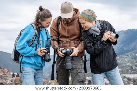 A group of young adult people friends colleagues professional photographers with cameras in their hands. Photo education, courses and tours 