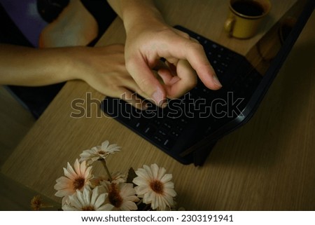 Close up view of male worker hand pointing on screen of digital tablet, working at wooden desk