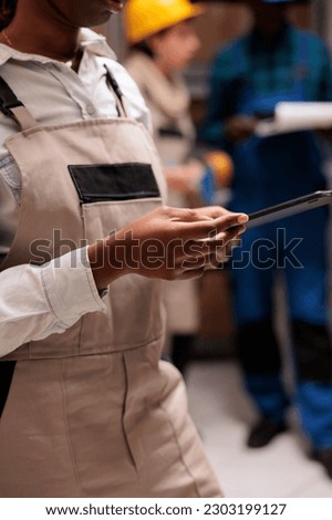 African american warehouse supervisor controlling goods inventory on digital tablet. Industrial storehouse woman employee coordinating parcels dispatching in app close up