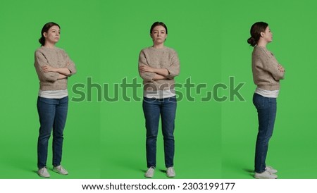 Caucasian woman standing over full body green screen backdrop, posing in front of camera. Girl model feeling confident and joyful sitting on greenscreen background in studio, casual look.