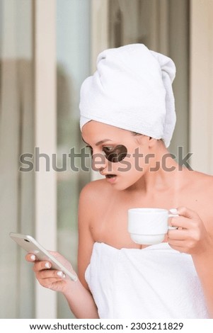 Shocked or surprised woman in under-eye patches reading message and drinking coffee at hotel terrace resort. morning holiday concept. bad news.