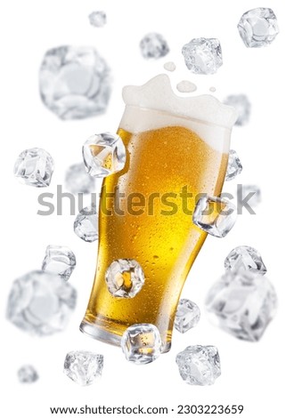 Beer glass surrounded with flying ice cubes. Conceptual picture of beer glass chilling.