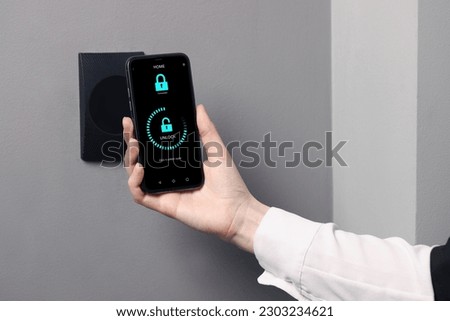 Woman unlocking door using mobile phone, closeup. Illustration of closed and open padlocks on device screen Royalty-Free Stock Photo #2303234621