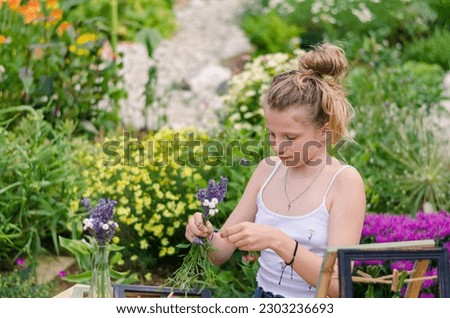adorable blond girl sitting in the garden creating lavender framed images