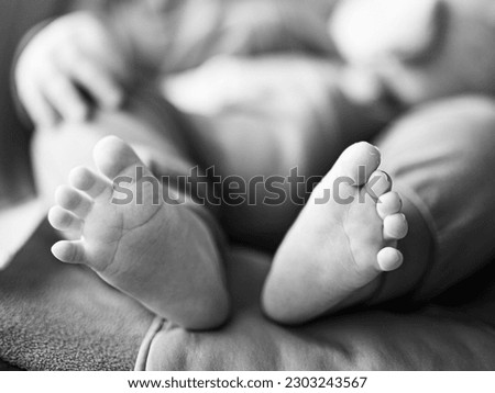 Close-up of cute little baby feet, innocence concept. Black and white image