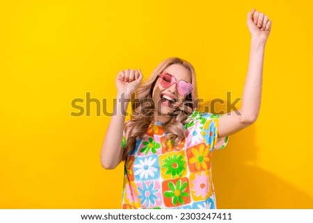 Photo excited pretty lady dancing summer youth party festival wear heart sunglass print shirt isolated yellow color background Royalty-Free Stock Photo #2303247411