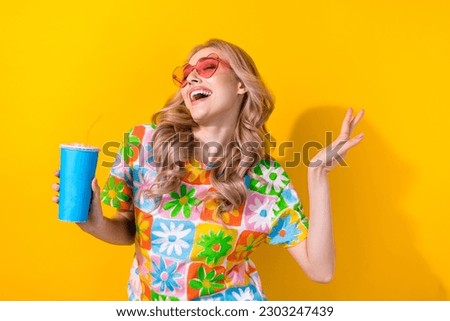 Photo cute dancing lady drink nonalcoholic beverage youth party wear heart sunglass print shirt isolated yellow color background Royalty-Free Stock Photo #2303247439