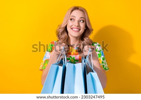 Photo of cute shopaholic lady hold many shopping packages read low prices poster wear shirt isolated yellow color background Royalty-Free Stock Photo #2303247495