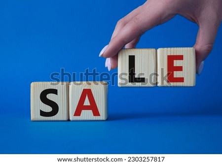 Sale symbol. Concept word Sale on wooden cubes. Businessman hand. Beautiful blue background. Business and Sale concept. Copy space.