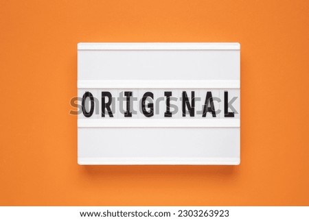 The word original on lightbox isolated orange background. Info concept