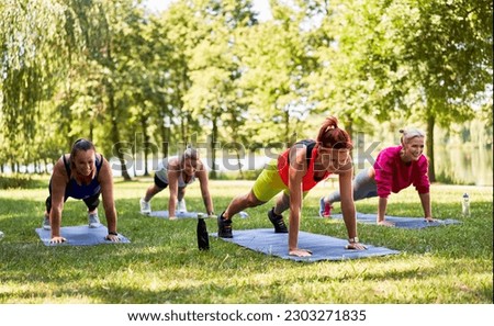 Group of women doing high plank exercise during outdoor fitness class. Royalty-Free Stock Photo #2303271835