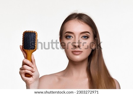 woman showing wooden brush and recommend haircare product