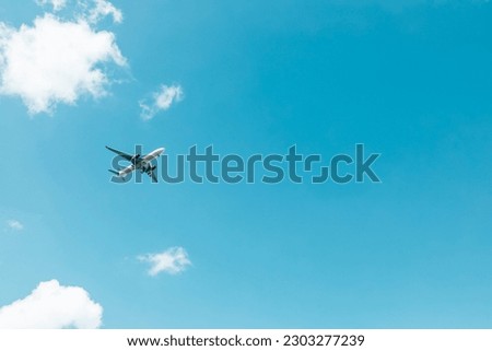 Airplane flying on blue sky Royalty-Free Stock Photo #2303277239
