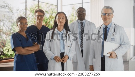 Team Portrait of a Female and Male Successful Diverse Medical Healthcare Professionals Standing as a Group in a Modern Hospital Office, Posing, Looking at Camera and Smiling Royalty-Free Stock Photo #2303277269