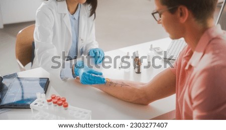 Close Up of a Patient Passing a Prick Scratch Allergy Test. Allergist Using Different Allergens on a Skin of a Young Man. Immunologist Diagnosing Allergy Triggers Royalty-Free Stock Photo #2303277407
