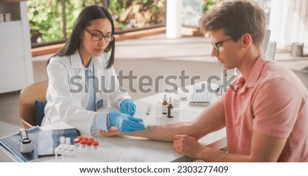 Female Healthcare Professional at Work in Hospital Office. Doctor Applying Different Solutions with Food Allergens on Patient's Forearm. Immunologist Diagnosing any Immediate Allergic Skin Reactions Royalty-Free Stock Photo #2303277409