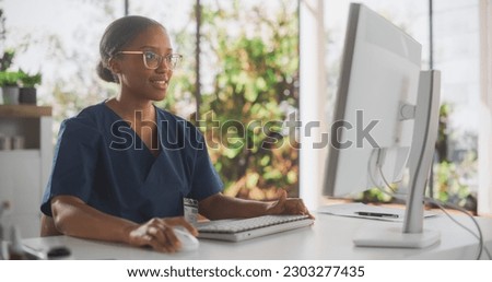 African Healthcare Nurse Using Desktop Computer for Day-to-Day Hospital Operations. Beautiful Young Clinic Professional Using PC for Online Medical Work in Modern Office in Public Health Care Facility
