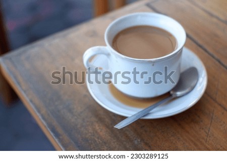 A cup of cafe at the table, minuman  susu kopi, baverage di cafe, minuman yang segar mengandung cafein. Menyehatkan dan menambah kerja jantung, biar sehat. Mengurangi kantuk menyegarkan badan dan ot