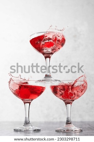 Three glasses with red liquid and splashes