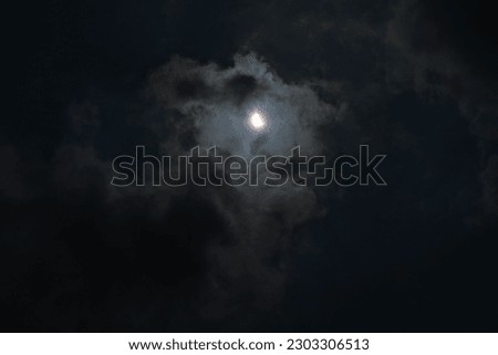 Hybrid Solar Eclipse.
The night sky is filled with dark clouds, illuminated by the bright full moon and its magical moonlight. Royalty-Free Stock Photo #2303306513