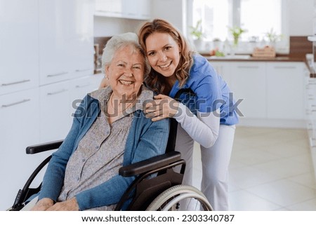 Portrait of nurse and her senior client on wheelchair. Royalty-Free Stock Photo #2303340787